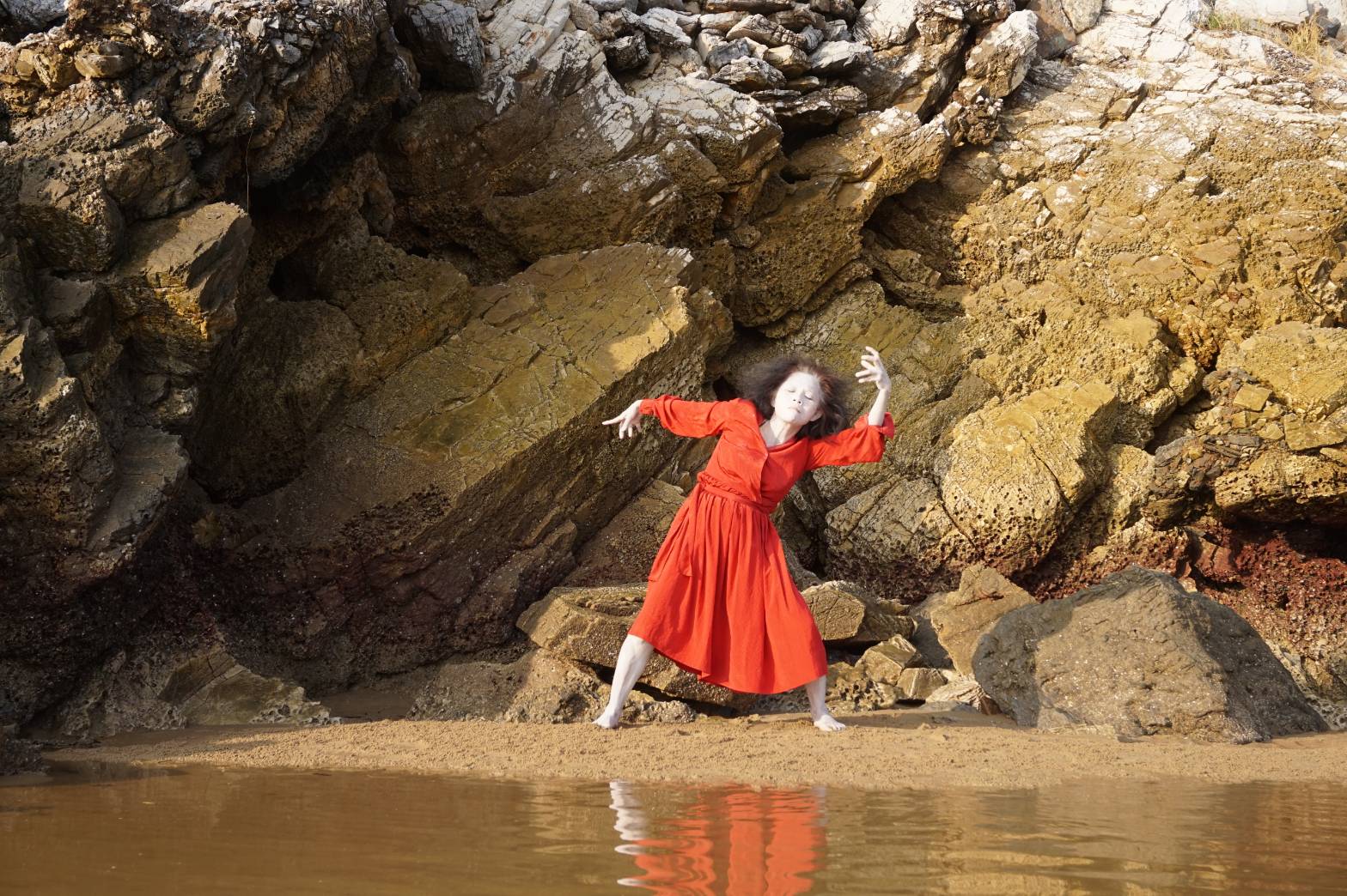 A woman in red performing outdoors