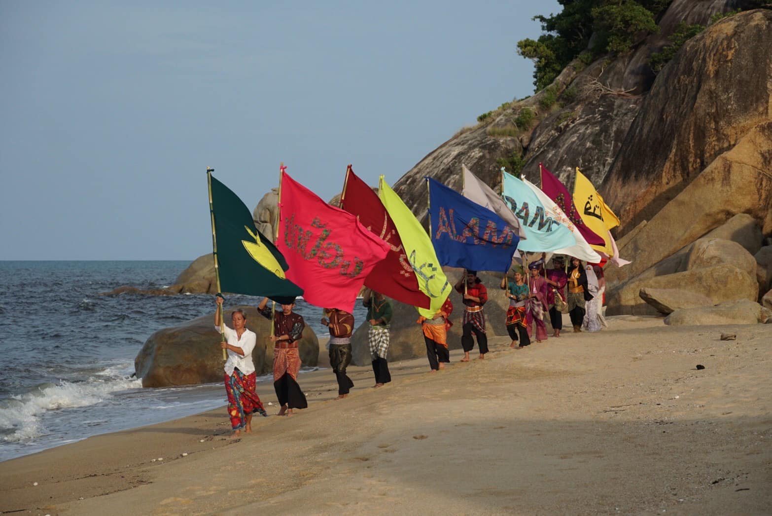 The Flag Project performance with many colorful flags in a mountainous landscape