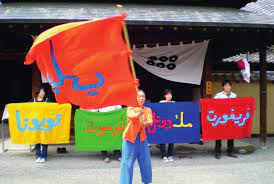 Arahmaiani holds a large orange flag